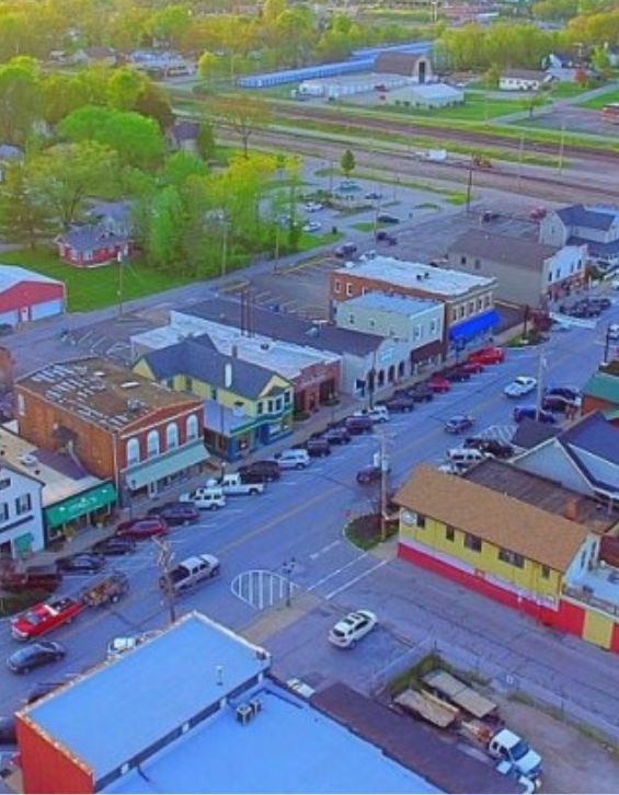 Aerial view of a small town main street featuring various shops and parked cars, showcasing a vibrant community atmosphere. This image highlights the importance of local services, including a reliable locksmith for residential and commercial security needs.