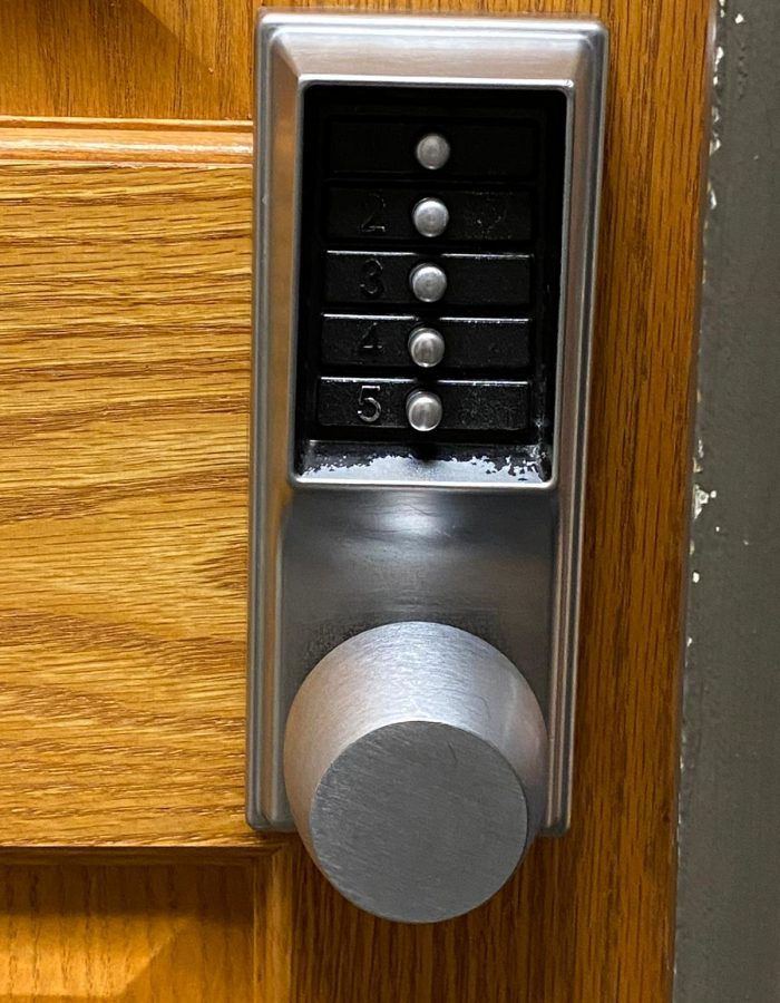 Locksmith in Bridgeton, MO 1 Close-up image of a combination lock mounted on a wooden door, featuring five numbered dials for code entry. This secure locking mechanism is often installed by professional locksmiths to enhance security in residential or commercial properties.